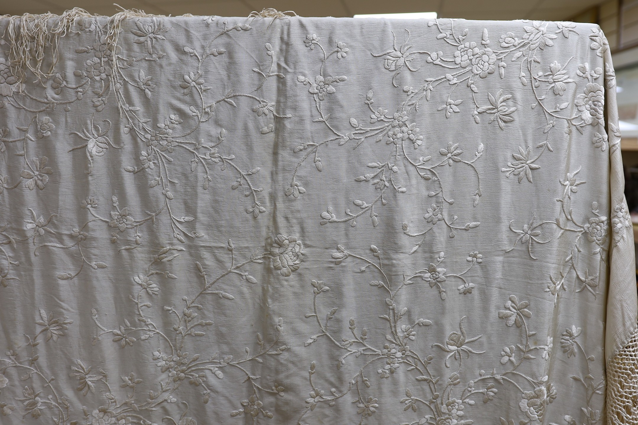 A Chinese late 19th century silk embroidered shawl, with cream on cream embroidery and a cream silk fringe, 140x134 cms